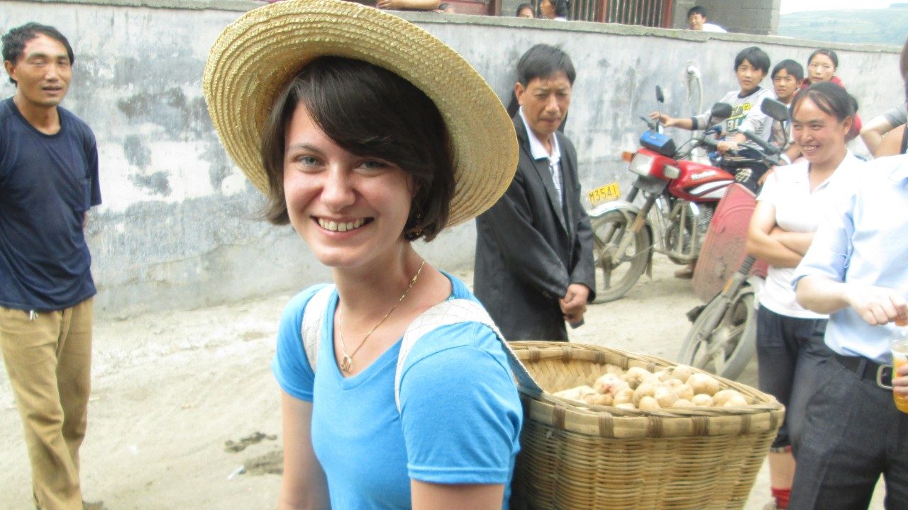 Stephanie Myrick carries traditional potato basket from field to market in China.