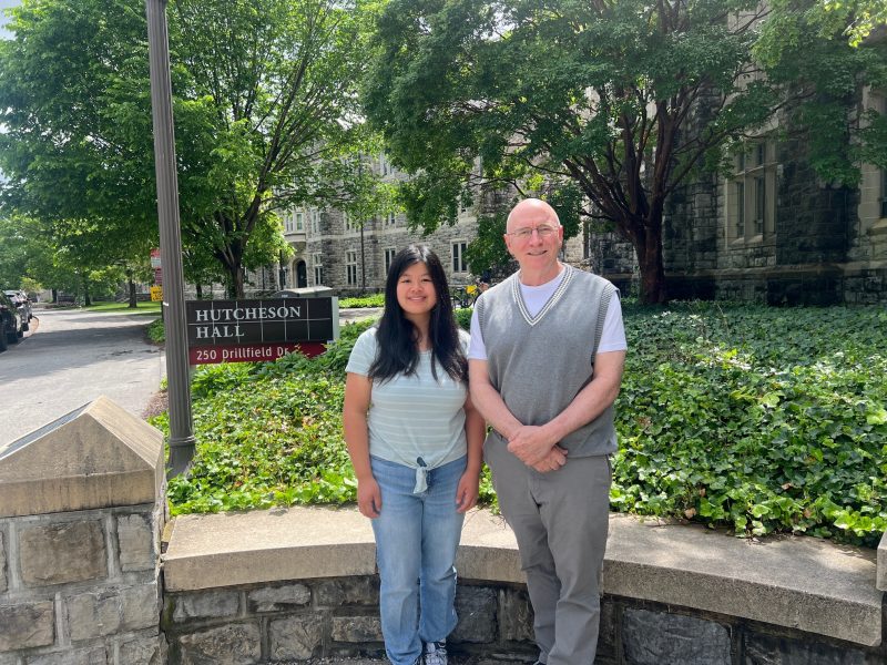 two people posing in front of building