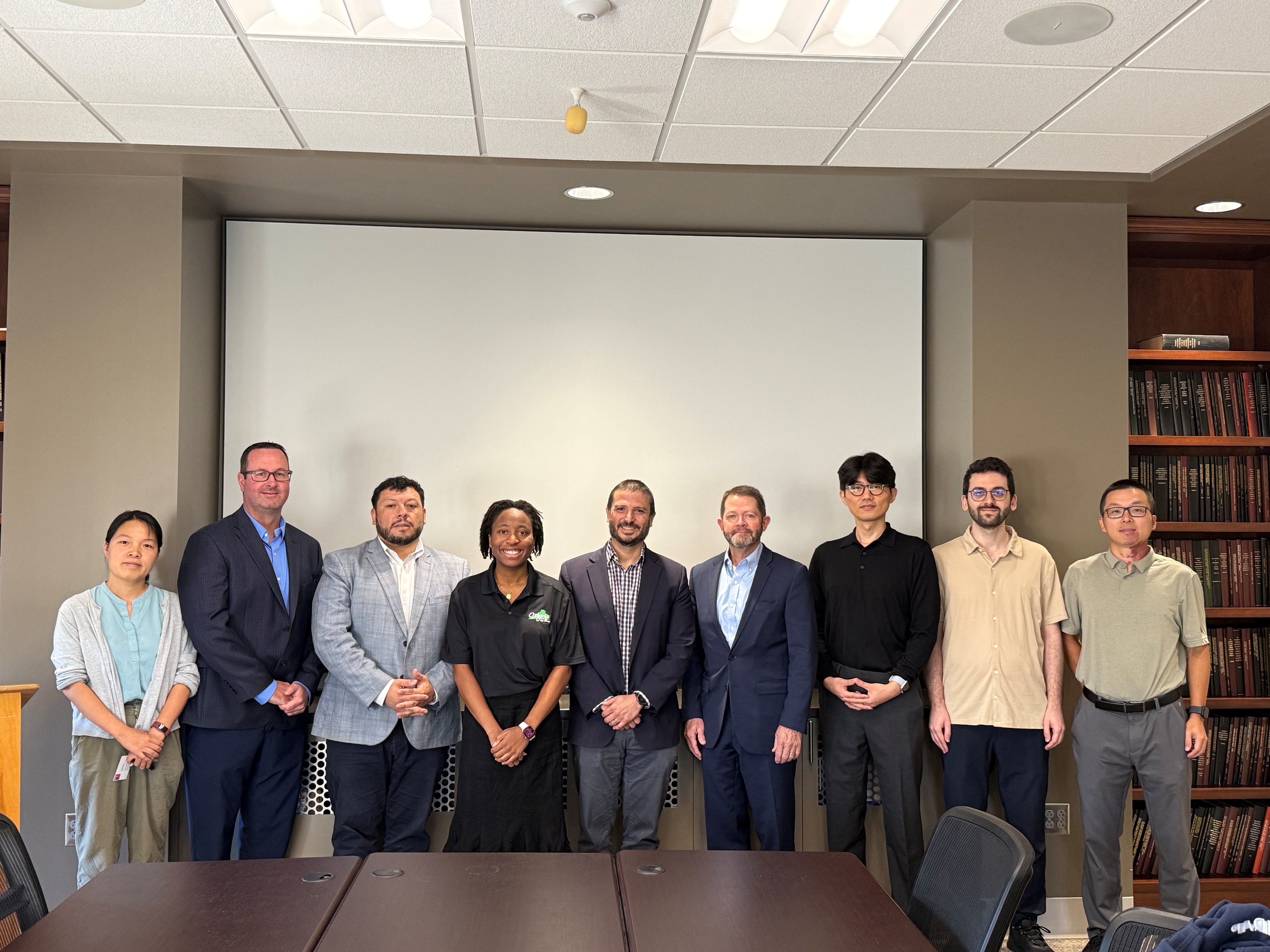 People standing in a conference room posing for a picture