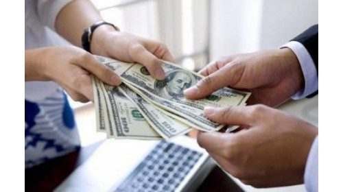 A women hands a man several $100 bills.