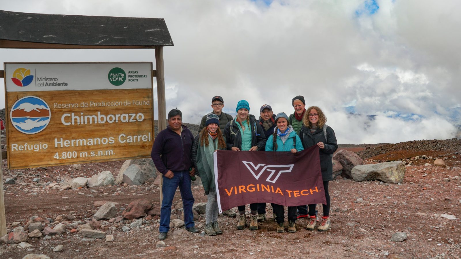 Students hold Virginia Tech flag on Chimborazo volcano.