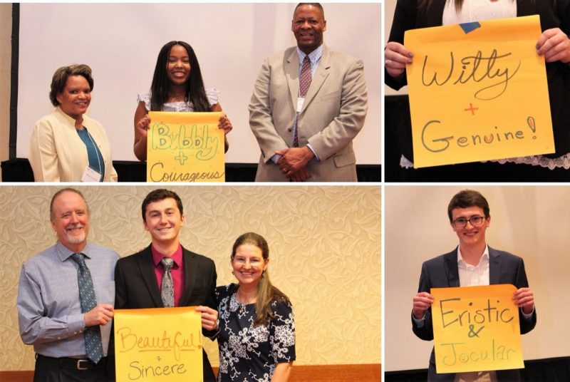 Students hold up signs with descriptive adjectives at the AAEC scholarship banquet.