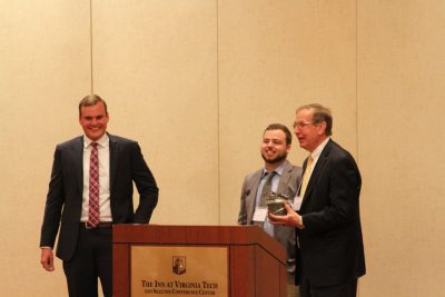 Ambassador Dick Crowder receives the 2018 outstanding faculty award from Ben Garber and Chandler Vaughn.