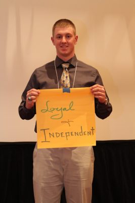 Mark Debnam holds up sign with the words "loyal and independent" on it.